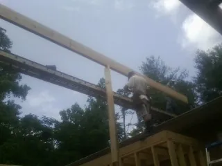 Carpenter setting a ridge beam over a new addition frame — Ice Dam Removal by Roofing Brothers in Thompsontown