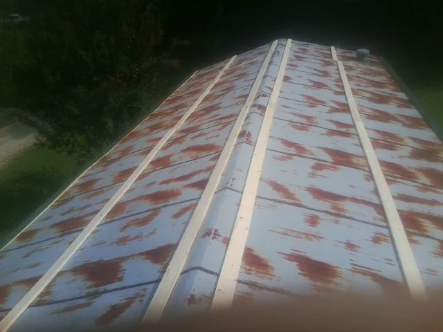 Rusted metal roof panels with new wood purlins before replacement — Storm Damage Roof Repair in Thompsontown by Roofing Brothers