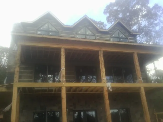 Dormers and porch framing on a large log home under construction — Roof Coating work by our crew in Thompsontown